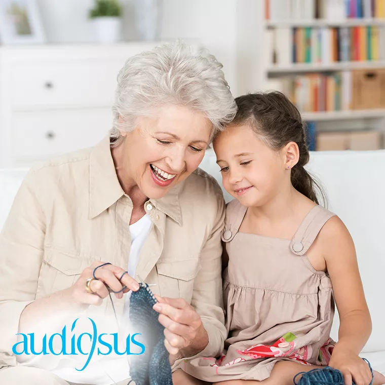 Fröhliche Dame nach erfolgreicher Audiosus Anpassung mit Enkelin
